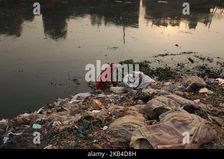 Una donna raccoglie plastica da un canale di rifiuti di plastica che conduce al fiume Buriganga a Dhaka, Bangladesh, il 5 gennaio 2019. Il Bangladesh è stato classificato 10th tra i primi 20 inquinatori di plastica del mondo con il fiume Buriganga noto come uno dei fiumi più inquinati del paese a causa del dilagante scarico di rifiuti industriali e umani. (Foto di Rehman Asad/NurPhoto) Foto Stock