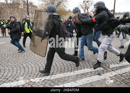 Un dimostratore è fermato dalla polizia antisommossa francese vicino all'Arco di Trionfo durante una manifestazione anti-governativa chiamata dal movimento dei gilet gialli 'Gilets Jaunes', a Parigi il 12 gennaio 2019. Migliaia di manifestanti anti anti-governativi hanno marciato in città in tutta la Francia il 12 gennaio 2010 in un nuovo round di proteste contro il presidente, accusati di ignorare la situazione di milioni di persone che lottano per raggiungere la fine. (Foto di Michel Stoupak/NurPhoto) Foto Stock