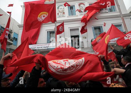 Gli unionisti sventolano bandiere tunisine e bandiere dell'Unione generale del lavoro tunisina (UGTT) in occasione del discorso tenuto da Noureddine Taboubi, segretario generale dell'UGTT, durante le celebrazioni del 8th° anniversario della rivoluzione tunisina, Tenuto fuori della sede della UGTT nella capitale Tunisi, Tunisia, il 14 gennaio 2019. (Foto di Chardy ben Ibrahim/NurPhoto) Foto Stock