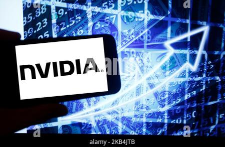 Il logo di Nvidia viene visualizzato sullo schermo di uno smartphone accanto a uno schermo con un'illustrazione del mercato azionario. NVIDIA è elencata in Nasdaq. Il Nasdaq è la seconda borsa più grande del mondo dopo la borsa di New York. (Foto di Alexander Pohl/NurPhoto) Foto Stock