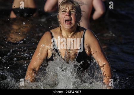 Una donna reagisce mentre si tuffa in acque ghiacciate per celebrare l'Epifania ortodossa a Kiev, Ucraina il 19 gennaio 2019. I cristiani ortodossi celebrano l'Epifania immergendosi in acque con temperature inferiori a zero gradi sul fiume Dnieper a Kiev. (Foto di Diego Herculano/NurPhoto) Foto Stock