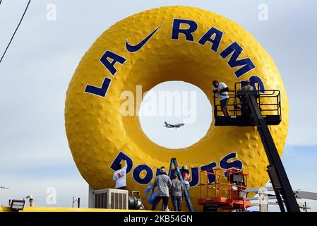 Un aeroplano che decolta da LAX è visto al centro dell'iconica insegna di Randy's Donuts, ridipinta per celebrare l'offerta di Los Angeles Rams' Super Bowl. Los Angeles, California il 29 gennaio 2019. I Los Angeles Rams giocheranno contro i New England Patriots nel Super Bowl. (Foto di Ronen Tivony/NurPhoto) Foto Stock