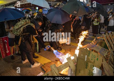 Un protester è visto usando una torcia di colpo per accendere i cardboard che sono usati per formare una barricata a Hong Kong il 6 settembre 2019, migliaia circondano la stazione di polizia di Mong Kok in protesta — il protester di Pro-democrazia stanno prendendo alle strade per il mese di passaggio per protestare — La polizia ha sparato gas lacrimogeno per disperdere il protester, che ha lanciato il fuoco per le barricate nelle strade. (Foto di Vernon Yuen/NurPhoto) Foto Stock