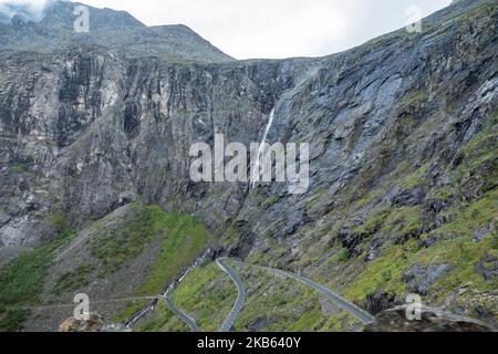 La famosa strada panoramica di montagna di Serpentine Trollstigen o Trollstigveien, il Sentiero Trolls, una strada di montagna con cascate nel comune di Rauma, più og contea di Romsdal, Norvegia. Il percorso fa parte della Norwegian County Road 63, che collega Andalsnes al fiordo di Valldal e Geiranger, Trollstigen fa parte della strada panoramica norvegese Geiranger - Trollstigen,. La strada è aperta solo durante la stagione estiva, è stretta con curve strette, ascendente 850 metri, con una grande cascata, Stigfossen di un'altezza di 240 metri e un ponte, centro visitatori per i turisti, piattaforma di osservazione visitatori. La vista dello Scandi Foto Stock