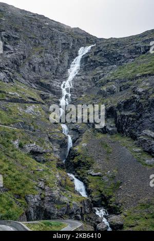 La famosa strada panoramica di montagna di Serpentine Trollstigen o Trollstigveien, il Sentiero Trolls, una strada di montagna con cascate nel comune di Rauma, più og contea di Romsdal, Norvegia. Il percorso fa parte della Norwegian County Road 63, che collega Andalsnes al fiordo di Valldal e Geiranger, Trollstigen fa parte della strada panoramica norvegese Geiranger - Trollstigen,. La strada è aperta solo durante la stagione estiva, è stretta con curve strette, ascendente 850 metri, con una grande cascata, Stigfossen di un'altezza di 240 metri e un ponte, centro visitatori per i turisti, piattaforma di osservazione visitatori. La vista dello Scandi Foto Stock