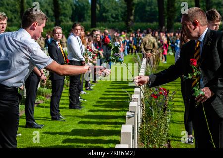 Settembre 22nd, Oosterbeek. Nel cimitero di guerra di Arnhem Oosterbeek, sono sepolti più di 1750 soldati alleati. Nell'ambito delle commemorazioni del 75th° anniversario dell'operazione Market Garden, si è svolto un servizio commemorativo alla presenza di veterani, loro parenti e migliaia di persone. Tradizionalmente i 'figli di fiori' del comune di Remkum depongono i fiori alle lapidi, quest'anno sono stati anche bambini di altri paesi che posavano i fiori alle lapidi. Su ogni tomba è posto un arco di pietra bianca, sul campo d'onore è una "Croce del sacrificio" fatta di pietra Portland, sulla quale è collocato un bronzo Foto Stock