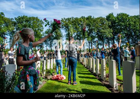 Settembre 22nd, Oosterbeek. Nel cimitero di guerra di Arnhem Oosterbeek, sono sepolti più di 1750 soldati alleati. Nell'ambito delle commemorazioni del 75th° anniversario dell'operazione Market Garden, si è svolto un servizio commemorativo alla presenza di veterani, loro parenti e migliaia di persone. Tradizionalmente i 'figli di fiori' del comune di Remkum depongono i fiori alle lapidi, quest'anno sono stati anche bambini di altri paesi che posavano i fiori alle lapidi. Su ogni tomba è posto un arco di pietra bianca, sul campo d'onore è una "Croce del sacrificio" fatta di pietra Portland, sulla quale è collocato un bronzo Foto Stock