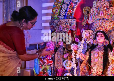 La donna decora l'idolo la Dea Durga con fiori di loto prima che le preghiere comincino durante il festival di Durga Puja ad un pandal (tempio temporaneo) a Mississauga, Ontario, Canada, il 28 settembre 2019. Centinaia di bengalesi (che ora sono emigrati in Canada da Kolkata, India) hanno partecipato alla celebrazione. Durga Puja è uno dei più grandi festival indù che coinvolge l'adorazione della dea Durga che simboleggia il potere e il trionfo del bene sul male nella mitologia indù. (Foto di Creative Touch Imaging Ltd./NurPhoto) Foto Stock