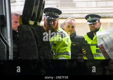 La polizia detenere un attivista della ribellione di estinzione dopo aver spruzzato sangue falso da un motore antincendio sopra e fuori l'edificio del Tesoro nel centro di Londra il 3 ottobre 2019. (Foto di Alberto Pezzali/NurPhoto) Foto Stock