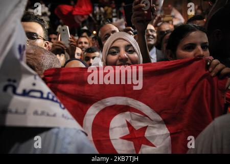 Una sostenitrice femminile del partito Ennahda, detiene una bandiera tunisina mentre partecipa al discorso di Rached Ghannouchi, leader del partito islamico tunisino Ennahda, tenuto fuori dalla sede del partito, Per celebrare la vittoria nelle elezioni legislative della Tunisia rivendicata dopo un sondaggio d'uscita di Sigma Conseil trasmesso dalla televisione statale, a Tunisi, Tunisia, 6 ottobre 2019. (Foto di Chardy ben Ibrahim/NurPhoto) Foto Stock