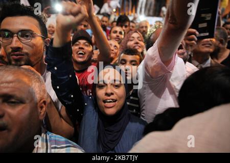 A female supporter of Ennahda party, raises her arms as she attends the speech of Rached Ghannouchi, leader of Tunisia’s Islamist Ennahda party held outside the headquarters of the party, to celebrate victory in Tunisia's legislative election claimed after an exit poll by Sigma Conseil broadcasted by state television, in Tunis, Tunisia October 6, 2019. (Photo by Chedly Ben Ibrahim/NurPhoto) Stock Photo