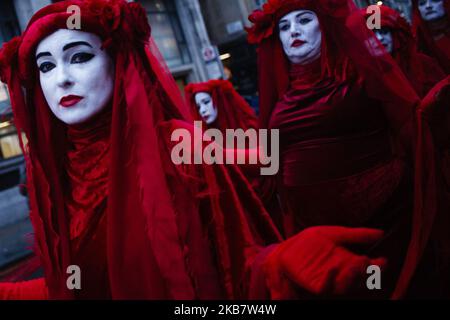 La 'Red Rebel Brigade' marcia silenziosamente lungo Whitehall come membri del gruppo attivista per il cambiamento climatico Extinction Rebellion (XR) blocca le strade il giorno di apertura della sua lunga ribellione internazionale a Londra, Inghilterra, il 7 ottobre 2019. I membri del gruppo intendono occupare 12 siti intorno agli edifici governativi di Westminster almeno fino a sabato 19 ottobre prossimo, con l'obiettivo di "mettere in secondo piano" l'area per esercitare pressioni sui legislatori affinché intraprendano ulteriori e più rapidamente azioni per arrestare la perdita di biodiversità e ridurre le emissioni di gas a effetto serra. Blocchi simili di estinzione Rebell Foto Stock