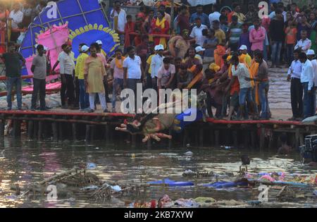 Indian hindu devotees immerse the idol Goddess Durga in a temporary pond , in Allahabad on October 8,2019. The immersion of the idols marks the end of five day festival that commemorates the slaying of a demon king by lion riding ,ten armed Goddess Durga,marking the triumph of Good over evil. (Photo by Ritesh Shukla ) (Photo by Ritesh Shukla/NurPhoto) Stock Photo