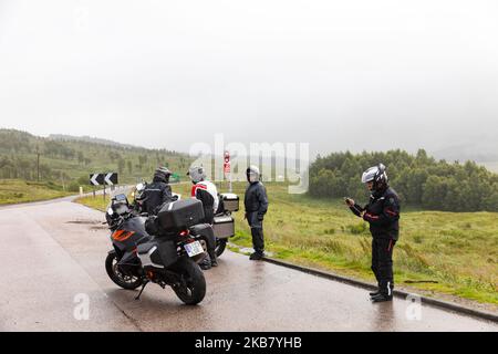 Tour motociclistico in Scozia gruppo di visitatori europei in giro su BMW R1250GS moto, Highlands scozzesi, Scozia, Regno Unito, nebbia giorno Foto Stock