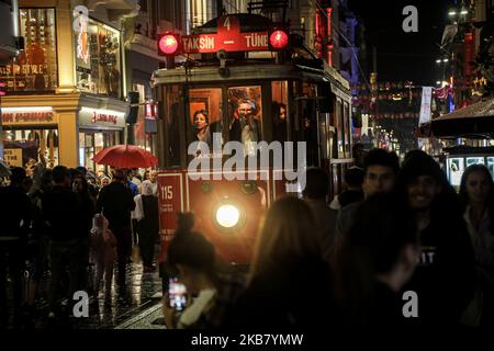 I turisti scattano foto ricordo con un tram rosso vecchio stile in Piazza Taksim e Via Istiklal in una giornata piovosa e fredda. La zona di Taksim di Istanbul è famosa per i suoi negozi, ristoranti, caffè, bar e discoteche 08 ottobre 2019, Istanbul, Turchia Istanbul (Foto di Momen Faiz/NurPhoto) Foto Stock