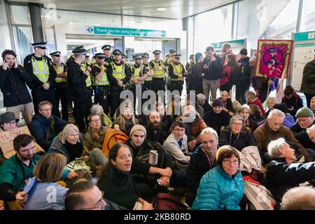 Gli attivisti ambientali della rivolta di estinzione occupano la City Airport DLR Station a Londra il 10 ottobre 2019 a Londra, Inghilterra. I manifestanti intendono bloccare l’aeroporto di Londra per tre giorni per evidenziare l’incompatibilità del suo piano di espansione da 2bn milioni di sterline con la risoluzione dell’emergenza climatica ed ecologica dichiarata dal Parlamento o con l’impegno giuridicamente vincolante del governo di diventare neutrale dal punto di vista del carbonio entro il 2050. (Foto di Wiktor Szymanowicz/NurPhoto) Foto Stock