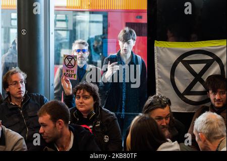 Gli attivisti ambientali della rivolta di estinzione occupano la City Airport DLR Station a Londra il 10 ottobre 2019 a Londra, Inghilterra. I manifestanti intendono bloccare l’aeroporto di Londra per tre giorni per evidenziare l’incompatibilità del suo piano di espansione da 2bn milioni di sterline con la risoluzione dell’emergenza climatica ed ecologica dichiarata dal Parlamento o con l’impegno giuridicamente vincolante del governo di diventare neutrale dal punto di vista del carbonio entro il 2050. (Foto di Wiktor Szymanowicz/NurPhoto) Foto Stock