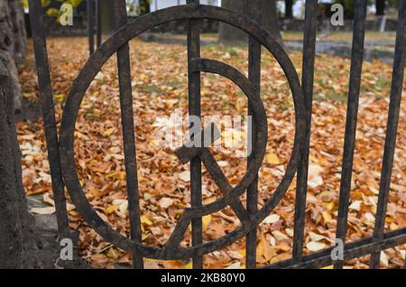 Una vista di un martello e falce, simboli comunisti all'ingresso del cimitero dell'esercito sovietico a Rzeszow. Qui sono sepolti 2.224 soldati russi. Furono uccisi nelle battaglie di Rzeszow e nelle zone circostanti. Giovedì 10 ottobre 2019 a Rzeszow, Polonia. Una vista della stella rossa sul monumento principale, nel cimitero dell'esercito sovietico a Rzeszow. Qui sono sepolti 2.224 soldati russi. Furono uccisi nelle battaglie di Rzeszow e nelle zone circostanti. (Foto di Artur Widak/NurPhoto) Foto Stock