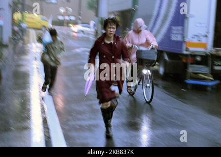 Un passerby che usa un ombrello lotta contro una pioggia e un vento pesanti mentre il tifone Hagibis si avvicina alla terraferma giapponese a Tokyo, Giappone, 11 ottobre 2019. (Foto di Hitoshi Yamada/NurPhoto) Foto Stock