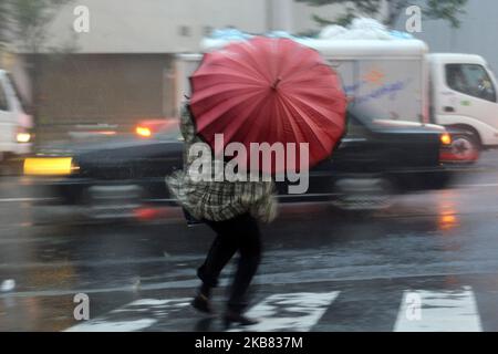 Un passerby che usa un ombrello lotta contro una pioggia e un vento pesanti mentre il tifone Hagibis si avvicina alla terraferma giapponese a Tokyo, Giappone, 11 ottobre 2019. (Foto di Hitoshi Yamada/NurPhoto) Foto Stock