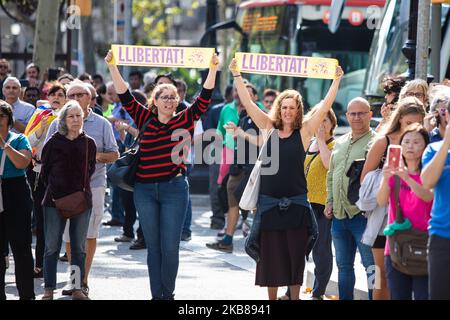 Due manifestanti con i manifesti della 'libertà' in una protesta a seguito della condanna di nove leader separatisti catalani il 14 ottobre 2019 a Barcellona, Spagna. La Corte Suprema spagnola ha condannato nove leader separatisti catalani a un periodo compreso tra nove e 13 anni di carcere per il loro ruolo nel referendum sull'indipendenza catalano del 2017. (Foto di Pau Venteo/NurPhoto) Foto Stock