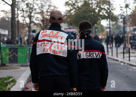 Due vigili del fuoco in attrezzatura di intervento, uno sul quale leggiamo 'in sciopero' e l'altro 'non riconosciuto rischio business' guardare gli scontri in polizia e dimostranti il 15 ottobre 2019, Mentre diverse migliaia di vigili del fuoco professionisti si sono manifestati nelle strade di Parigi per una grande giornata di mobilitazione nazionale su invito di tutti i sindacati. Questo giorno di mobilitazione era inteso a denunciare le loro condizioni di lavoro, la mancanza di mezzi e il mancato riconoscimento come un lavoro rischioso. (Foto di Samuel Boivin/NurPhoto) Foto Stock