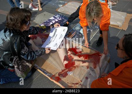 After putting a man coevred with flase blood in a shrink-wrapped tray, a L214 member prepares to put a sticker on the man reading 'Human Meat, France origine, net weigh: 70kg, €15/kg'. Protesters of the association L214 made an happening in Toulouse to raise awareness about meat consumption: some L214 members put themselves in a shrink-wrapped tray and were covered with false blood with a sticker reading 'Human meat, France Origine'. The L214 association became famous for its numerous films made in slaughterhouses. Their films depicted torture and abuse of livestock in some slaughterhouses. To Stock Photo