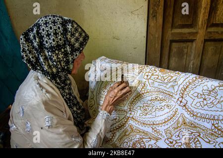 Un'artista batik donna che crea vari disegni con uno strumento simile a una penna chiamato un cantare come parte del processo di fabbricazione indonesiano batik a Bantul, Yogyakarta, Indonesia il 15 ottobre 2019. Batik è l'arte e la cultura originale dell'Indonesia fatta con un panno che tradizionalmente sta usando una tecnica generica di tintura cera-resistente. (Foto di Rizqullah Hamiid/NurPhoto) Foto Stock