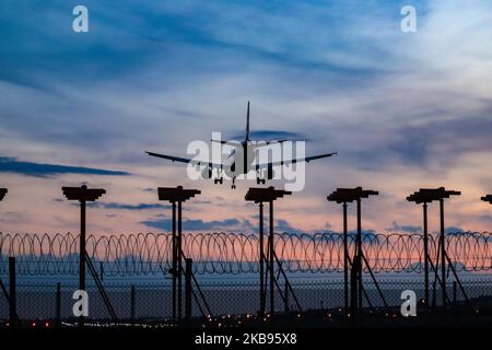 Silhouette di aeroplano durante l'atterraggio finale, durante il tramonto, il crepuscolo e l'ora magica presso la capitale britannica, London Heathrow International Airport EGLL LHR in Inghilterra, Regno Unito. Gli aeromobili Boeing e Airbus atterrano sulla pista settentrionale sopra le antenne degli strumenti di radionavigazione. (Foto di Nicolas Economou/NurPhoto) Foto Stock