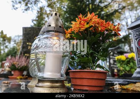 Tombe con croci cattoliche decorate con fiori e candele al cimitero di Oliwa sono viste a Danzica, Polonia il 26 ottobre 2019 come prima del 1st novembre, Giornata dei Santi (Wszystkich Swietych), le persone pagano rispetto per i membri della famiglia morti, pulire le loro tombe di famiglia, e molti fiori e candele sono posti sulla cima delle tombe. Tutti i Santi il 1 novembre e tutti i Souls' Day il 2 novembre sono quando milioni di polacchi visitano le tombe di persone care, spesso viaggiando per centinaia di chilometri verso le loro città (Foto di Michal Fludra/NurPhoto) Foto Stock