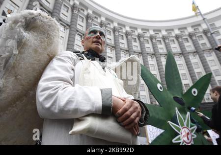 La gente partecipa a un rally "la marcia della canapa della libertà", chiedendo la legalizzazione dell'uso di marijuana, presso il Gabinetto dei ministri dell'Ucraina a Kyiv, Ucraina, il 26 ottobre 2019. Un gruppo di attivisti si è riunito per chiedere ai funzionari ucraini la riforma della politica statale in materia di droga, la depenalizzazione dell'uso della marijuana e la revisione da parte del Parlamento di un disegno di legge sulla cannabis medica. (Foto di Str/NurPhoto) Foto Stock