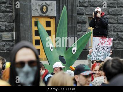 La gente partecipa a un rally "la marcia della canapa della libertà", chiedendo la legalizzazione dell'uso di marijuana, presso il Gabinetto dei ministri dell'Ucraina a Kyiv, Ucraina, il 26 ottobre 2019. Un gruppo di attivisti si è riunito per chiedere ai funzionari ucraini la riforma della politica statale in materia di droga, la depenalizzazione dell'uso della marijuana e la revisione da parte del Parlamento di un disegno di legge sulla cannabis medica. (Foto di Str/NurPhoto) Foto Stock