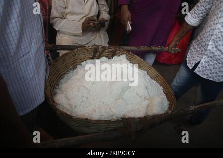 I devoti indiani che raccolgono riso santo durante l'Annakut Utsav (Govardhan Puja) a Madan Mohon Mandir il 29,2019 ottobre a Kolkata, in India. Le persone in gran numero si riuniscono al tempio e raccolgono le offerte di riso nella convinzione che il riso le manterrà in buone condizioni e mai nella vita si troverà ad affrontare la povertà o la scarsità di cibo. (Foto di Debajyoti Chakraborty/NurPhoto) Foto Stock