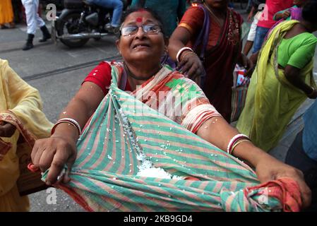 I devoti indiani che raccolgono riso santo durante l'Annakut Utsav (Govardhan Puja) a Madan Mohon Mandir il 29,2019 ottobre a Kolkata, in India. Le persone in gran numero si riuniscono al tempio e raccolgono le offerte di riso nella convinzione che il riso le manterrà in buone condizioni e mai nella vita si troverà ad affrontare la povertà o la scarsità di cibo. (Foto di Debajyoti Chakraborty/NurPhoto) Foto Stock