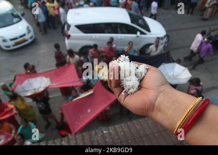 I devoti indiani che raccolgono riso santo durante l'Annakut Utsav (Govardhan Puja) a Madan Mohon Mandir il 29,2019 ottobre a Kolkata, in India. Le persone in gran numero si riuniscono al tempio e raccolgono le offerte di riso nella convinzione che il riso le manterrà in buone condizioni e mai nella vita si troverà ad affrontare la povertà o la scarsità di cibo. (Foto di Debajyoti Chakraborty/NurPhoto) Foto Stock