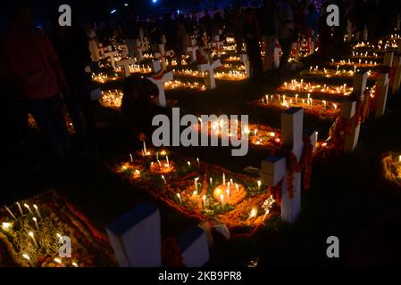 I cattolici del Bangladesh pregano dopo aver acceso le candele per i loro parenti defunti in un cimitero di Dhaka, Bangladesh, il 02 novembre 2019. I devoti cristiani osservano il giorno di tutte le anime, conosciuto come la Festa di tutte le anime, la Commemorazione di tutti i fedeli defunti. In questo giorno, i cristiani vengono nel cimitero e pregano per le anime defunte dei loro cari. All Soul's Day è un giorno cattolico romano di memoria per gli amici e i cari che sono passati. Ciò deriva dall'antica festa pagana dei morti, che celebrava la credenza pagana che le anime dei morti sarebbero ritornate per un pasto Foto Stock