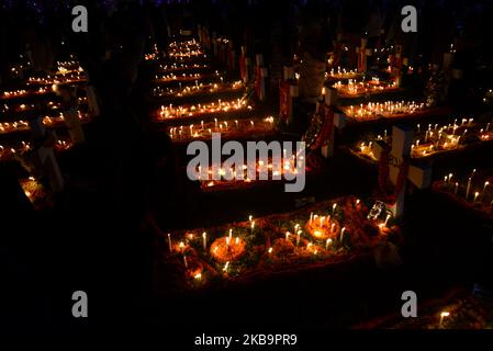 I cattolici del Bangladesh pregano dopo aver acceso le candele per i loro parenti defunti in un cimitero di Dhaka, Bangladesh, il 02 novembre 2019. I devoti cristiani osservano il giorno di tutte le anime, conosciuto come la Festa di tutte le anime, la Commemorazione di tutti i fedeli defunti. In questo giorno, i cristiani vengono nel cimitero e pregano per le anime defunte dei loro cari. All Soul's Day è un giorno cattolico romano di memoria per gli amici e i cari che sono passati. Ciò deriva dall'antica festa pagana dei morti, che celebrava la credenza pagana che le anime dei morti sarebbero ritornate per un pasto Foto Stock