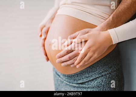 Gravidanza foto uomo e donna che tiene incinta urto in attesa di bambino. Mani di famiglia felici sul primo piano dello stomaco. Coppia innamorata. Foto Stock