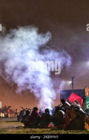 I venditori di cammelli si scaldano durante la notte fredda dopo la pioggia pesante alla fiera di Pushkar, Rajasthan, India, 03 novembre 2019.Thouses dei commercianti di bestiame dalla regione vengono alla fiera tradizionale del cammello dove il bestiame, principalmente cammelli, è commerciato. La fiera annuale del cammello e del bestiame è una delle più grandi fiere mondiali del cammello. (Foto di Vishal Bhatnagar/NurPhoto) Foto Stock