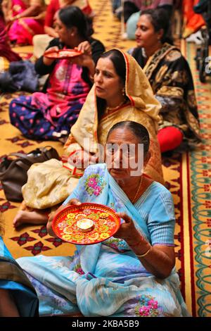 I devoti indù si esibiscono in aarti presso il tempio Swaminarayan di BAPS Shri durante l'Annakut Darshan (noto anche come Annakut Utsav e Govardhan Puja) che si svolge il quinto e ultimo giorno del festival di Diwali, Che segna l'inizio del nuovo anno indù, a Toronto, Ontario, Canada, il 28 ottobre 2019. Annakut, che significa "una grande montagna di cibo" che viene offerto a Dio come segno di devozione. BAPS (Bochasanwasi Shri Akshar Purushottam Swaminarayan Sanstha) è una setta dei vidhi diksha dell'Induismo e dei loro templi, sebbene dedicati a molte divinità indù, operano anche come comunità e come CE imparante Foto Stock