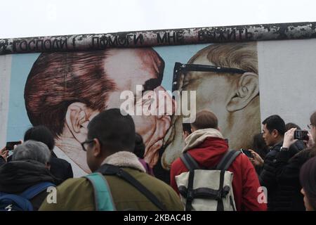 I visitatori scattano foto di un murale dell'artista russo Dmitri Vrubel "il mio Dio, aiutami a sopravvivere a questo amore mortale", Comunemente noto come “bacio fraterno”, che mostra l’ex leader dell’Unione Sovietica Leonid Brezhnev baciare l’ex leader tedesco orientale Erich Honecker in una sezione ancora in piedi dell’ex Muro di Berlino chiamata East Side Gallery, vista alla vigilia del prossimo 30th° anniversario della caduta del Muro di Berlino. Venerdì 8 novembre 2019 a Berlino, Germania. (Foto di Artur Widak/NurPhoto) Foto Stock