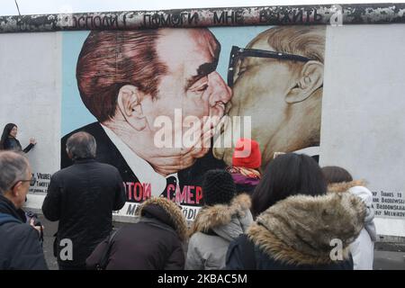 I visitatori scattano foto di un murale dell'artista russo Dmitri Vrubel "il mio Dio, aiutami a sopravvivere a questo amore mortale", Comunemente noto come “bacio fraterno”, che mostra l’ex leader dell’Unione Sovietica Leonid Brezhnev baciare l’ex leader tedesco orientale Erich Honecker in una sezione ancora in piedi dell’ex Muro di Berlino chiamata East Side Gallery, vista alla vigilia del prossimo 30th° anniversario della caduta del Muro di Berlino. Venerdì 8 novembre 2019 a Berlino, Germania. (Foto di Artur Widak/NurPhoto) Foto Stock