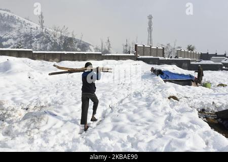 Le persone nomadi hanno ripulito la tenda di fortuna dopo che è stata dannata da forti nevicate nella periferia di Srinagar, indiano amministrato kashmir il 08 novembre 2019. La valle del Kashmir ha ricevuto la sua prima nevicata il giovedì che ha danneggiato la proprietà in molti luoghi ha provocato l'uccisione di sette persone. (Foto di Muzamil Mattoo/NurPhoto) Foto Stock