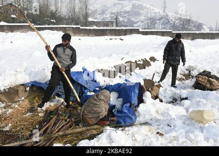 Le persone nomadi hanno ripulito la tenda di fortuna dopo che è stata dannata da forti nevicate nella periferia di Srinagar, indiano amministrato kashmir il 08 novembre 2019. La valle del Kashmir ha ricevuto la sua prima nevicata il giovedì che ha danneggiato la proprietà in molti luoghi ha provocato l'uccisione di sette persone. (Foto di Muzamil Mattoo/NurPhoto) Foto Stock