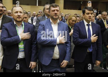 Il presidente neoeletto del partito politico 'Servo del popolo' (Sluga Narodu) Oleksandr Kornienko (C) e il presidente del Parlamento ucraino Dmytro Razumkov (R) cantano l'inno nazionale ucraino durante il congresso del partito a Kyiv, in Ucraina, il 10 novembre 2019. Oleksandr Kornienko è stato eletto nuovo capo del partito al congresso del partito. (Foto di Str/NurPhoto) Foto Stock