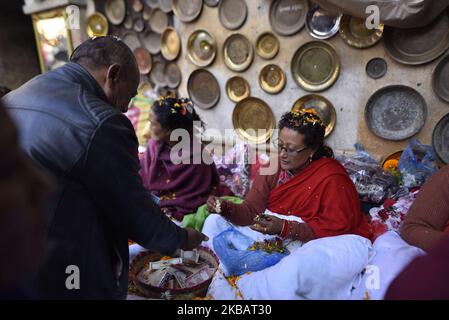 Una donna indù nepalese, che sta digiunando dando fiori santi ai devoti l'ultimo giorno del festival di Adinath Mela a Chobhar, Kirtipur, Kathmandu, Nepal martedì 12 novembre, 2019. Nel mese di ottobre o novembre da Kojagrat purnima a Kartik purnima per un mese, la gente visita il tempio di Adinath in mattinata per eseguire speciali rituali puja e funzione rituale durante Adinath Mela. (Foto di Narayan Maharjan/NurPhoto) Foto Stock