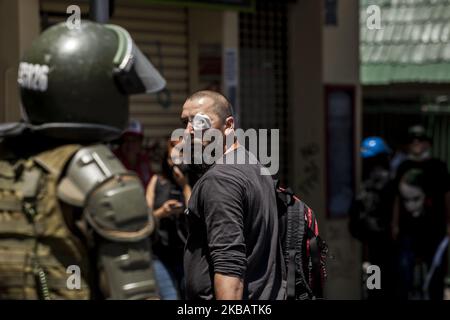 Santiago, Cile. 11 novembre 2019. Protester con un occhio con patch discute con la polizia. Nelle città di tutto il paese, i cileni hanno organizzato uno sciopero generale per chiedere l'istruzione pubblica gratuita, il miglioramento del sistema sanitario e le riforme del sistema pensionistico a Santiago, Cile. (Foto di Fernando Lavoz/NurPhoto) Foto Stock