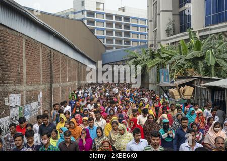 I lavoratori di indumenti pronti (RMG) che escono da una fabbrica durante la pausa pranzo a Narayanganj il 18 novembre 2019. (Foto di Ziaul Haque/NurPhoto) Foto Stock