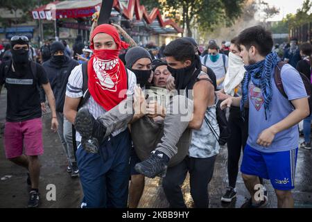 I volontari trasportano un protester anti-governativo colpito da gas lacrimogeno lanciato dai poliziotti riot cileni durante una protesta a Santiago, Cile, il 31 ottobre 2019. (Foto di Jeremias Gonzalez/NurPhoto) Foto Stock