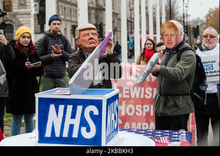 I manifestanti che indossano le maschere di Donald Trump e Boris Johnson insieme ai sostenitori del mantenimento del servizio sanitario nazionale (NHS) di proprietà pubblica si riuniscono al di fuori delle Camere del Parlamento per chiedere la fine della privatizzazione dell'assistenza sanitaria nell'NHS il 25 novembre 2019 a Londra, Inghilterra. I dimostranti protestano contro l’inclusione dell’NHS in un accordo commerciale tra Regno Unito e Stati Uniti dopo la Brexit. (Foto di Wiktor Szymanowicz/NurPhoto) Foto Stock
